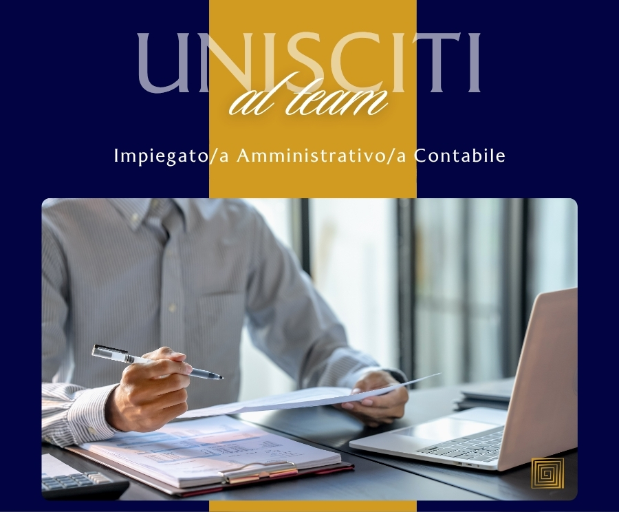 Una persona in camicia lavora a una scrivania con documenti, una penna e un laptop; sullo sfondo si vede una grafica con la scritta 'UNISCITI al team' e la descrizione di ruolo 'Impiegato/a Amministrativo/a Contabile'.